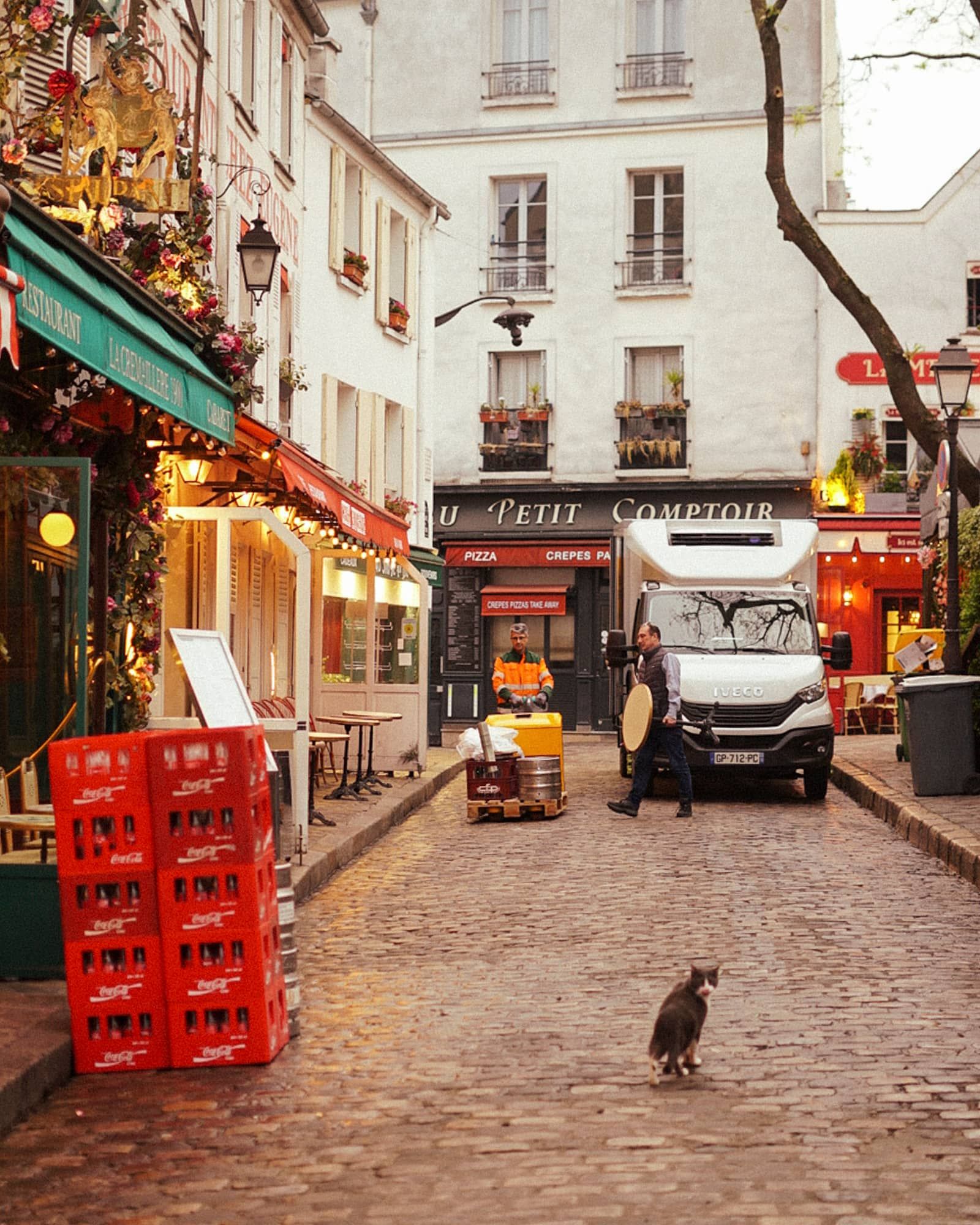 Tôt le matin sur la Place : les livraisons, les caisses sur le pavé, un chat qui traverse