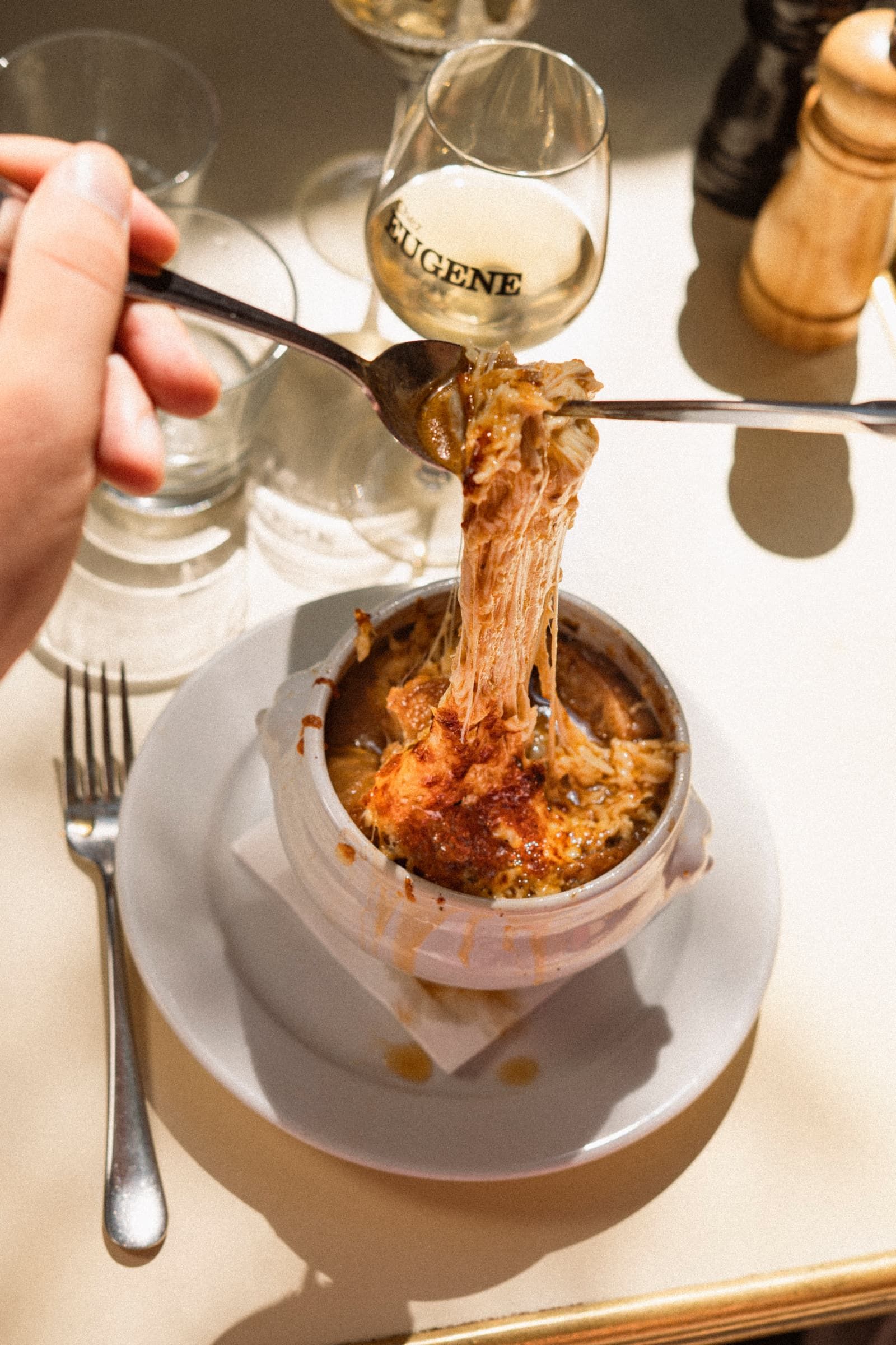 Soupe à l'oignon gratinée de Chez Eugène à Montmartre, le Cantal qui file à la cuillère