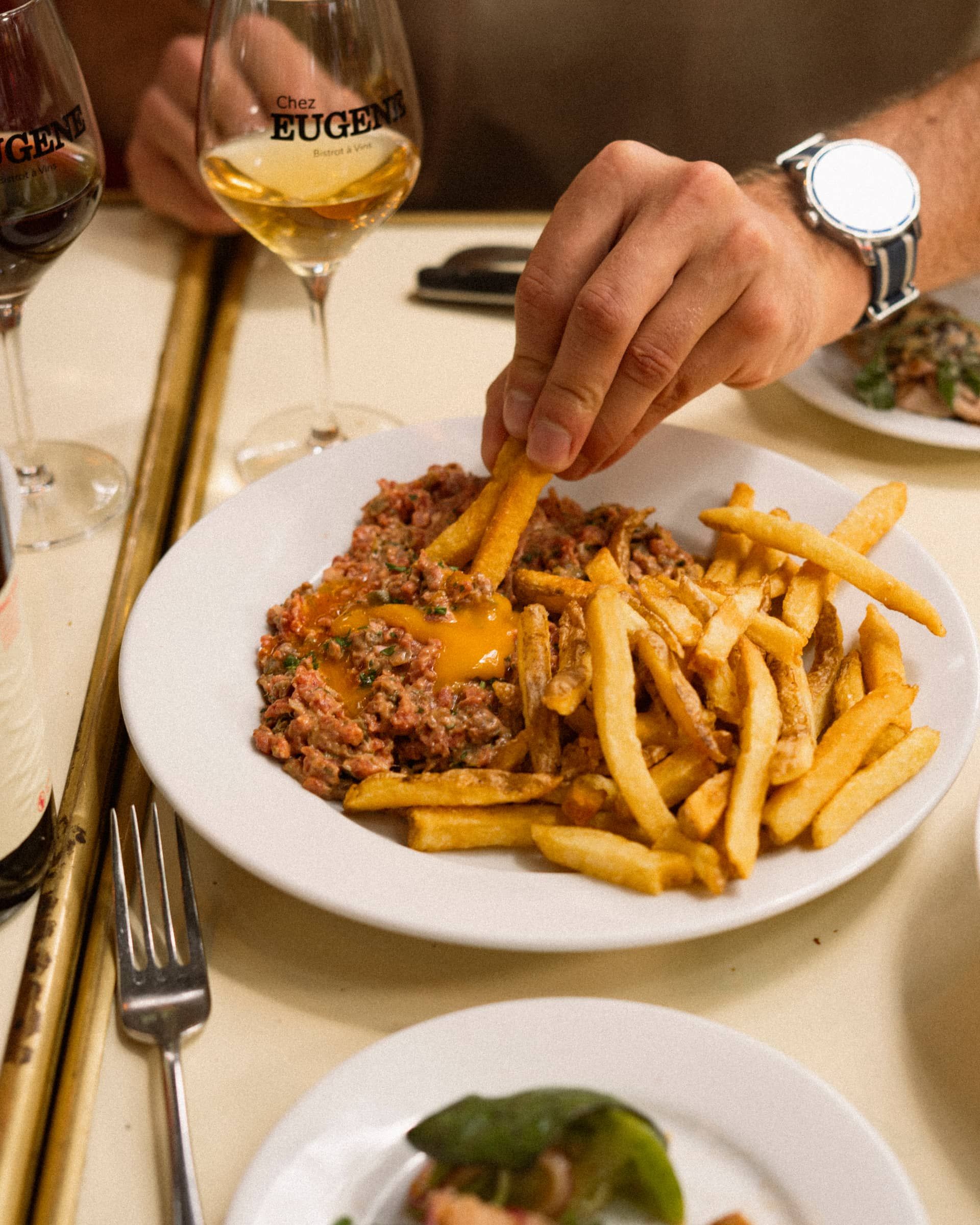 A plate with home-made chips, a hand stealing one