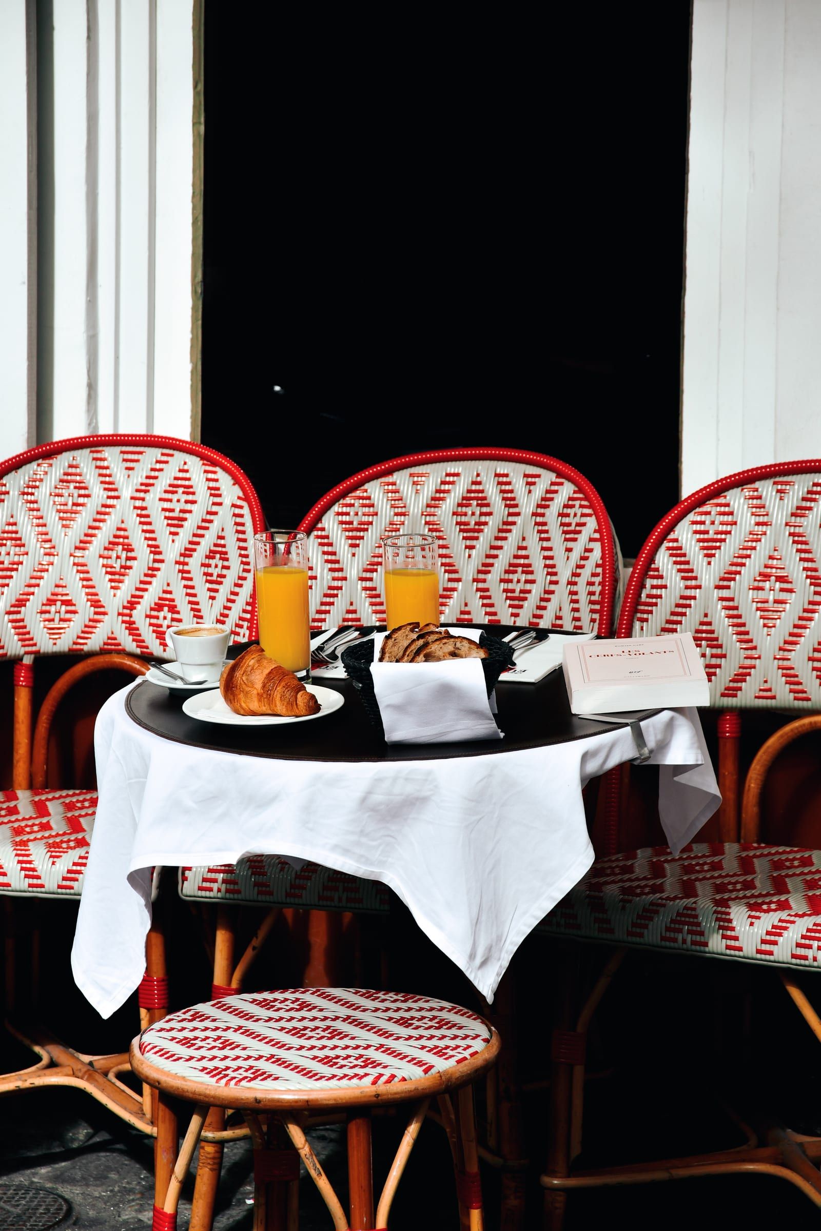 Une table dressée pour le petit-déjeuner sur la terrasse de Chez Eugène : croissant, jus d'orange et café