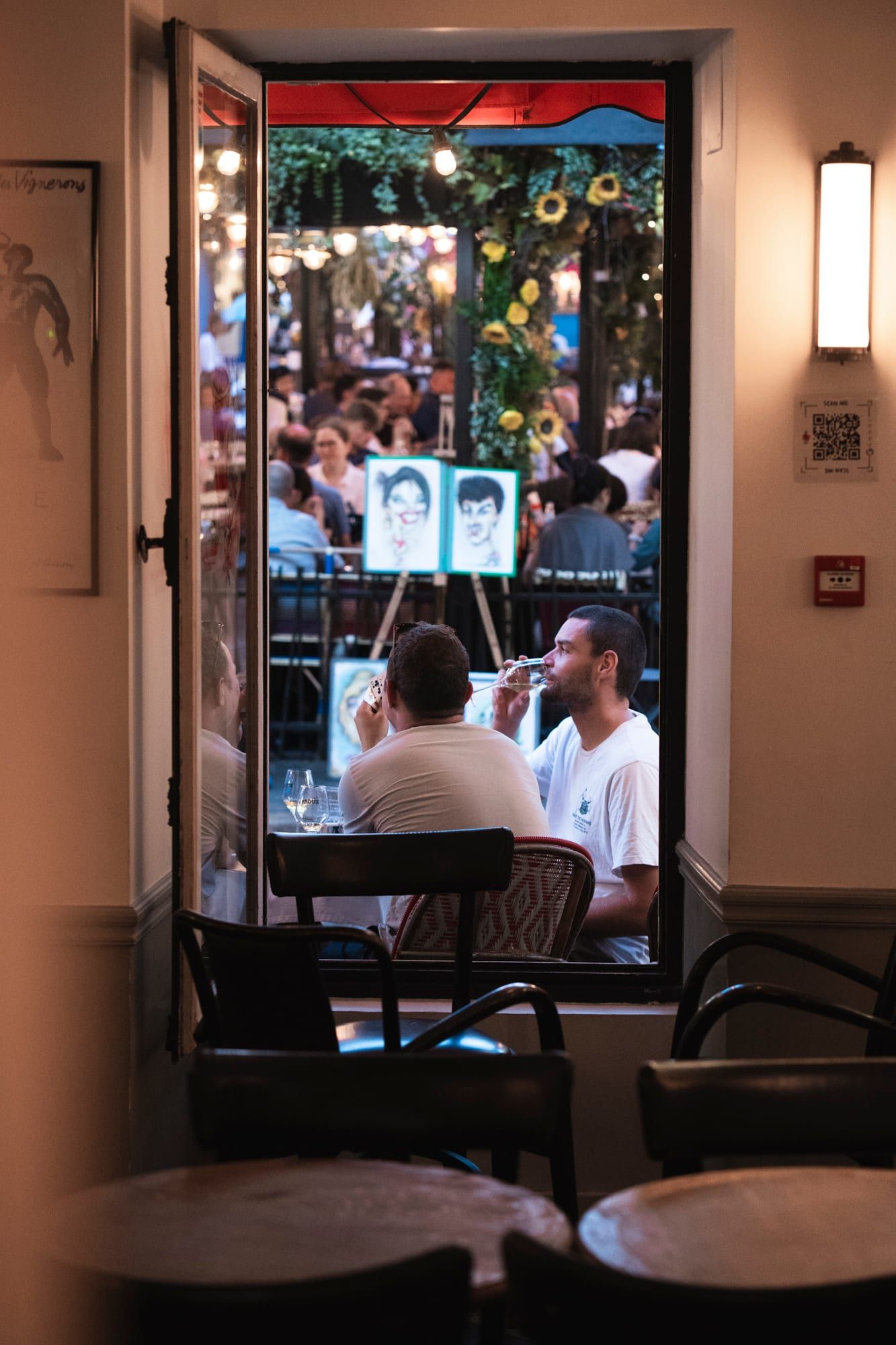 La terrasse de Chez Eugène pleine, sous le store rouge, place du Tertre à Montmartre