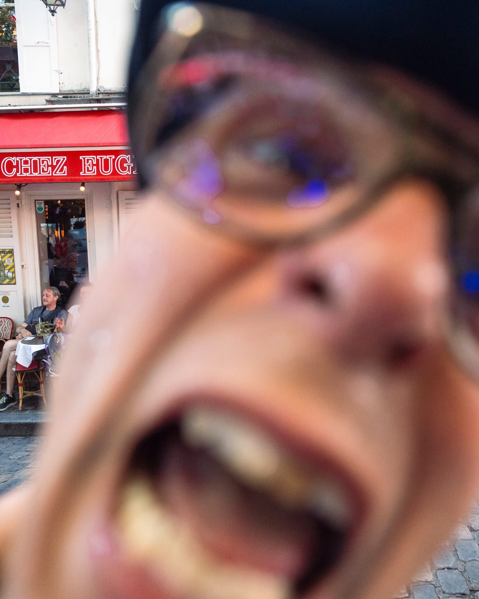 Une grimace à l'objectif, la façade derrière